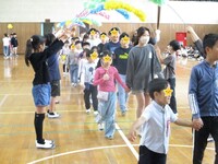 6年生と手をつないで入場です。花のアーチは4年生です